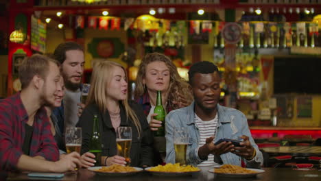 Group-Of-Happy-Multiracial-Friends-Making-A-Toast-With-Beer-At-Bar-Or-Pub.